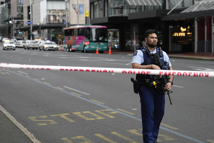 An armed New Zealand police officer stands at a road block in the central business district following a shooting in Auckland, New Zealand, Thursday, July 20, 2023. New Zealand police are responding to reports that a gunman has fired shots in a building in downtown Auckland.