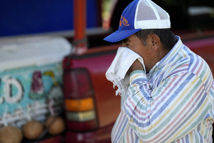 Andres Matamoros wipes the sweat from his face while selling fresh fruit and cold coconuts from his roadside stand on June 28, 2023, in Houston. Nearly 400 daily maximum temperature records fell in the South in June and the first half of July, most of them in Texas.