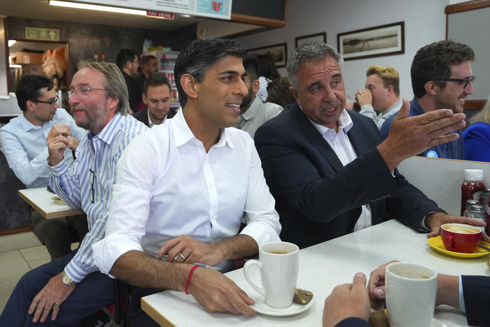 Britain's Prime Minister Rishi Sunak, center, and newly elected Conservative MP Steve Tuckwell, center right, speak at the Rumbling Tum cafe in Uxbridge, after Tuckwell won the Uxbridge and South Ruislip by-election, west London, Friday July 21, 2023.