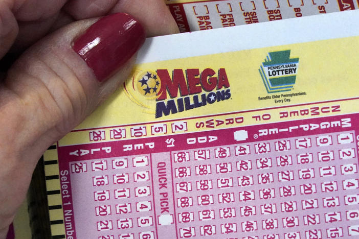 A Mega Millions wagering slip is held in Cranberry Township, Pa., on Jan. 12, 2023.