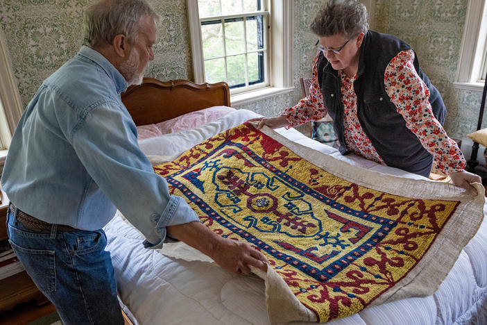 John Shambroom and Loose Ends volunteer Jan Rohwetter examine the rug Shambroom's wife, Donna Savastio, couldn't finish due to symptoms of Alzheimer's.