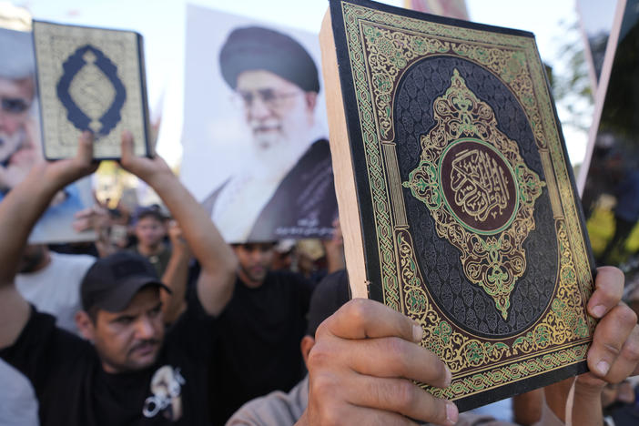 Iraqis raise copies of the Quran, Muslims' holy book, during a protest in Baghdad, Saturday. Hundreds of protesters attempted to storm Baghdad's heavily fortified Green Zone, which houses foreign embassies and the seat of Iraq's government, following reports of the burning of a Quran by a ultranationalist group in front of the Iraqi Embassy in Copenhagen.