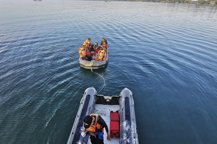 In this photo provided by the National Search and Rescue Agency (BASARNAS), rescuers on a rubber boat search for survivors after an overloaded ferry sank off Sulawesi Island, Indonesia, Monday, July 24, 2023.