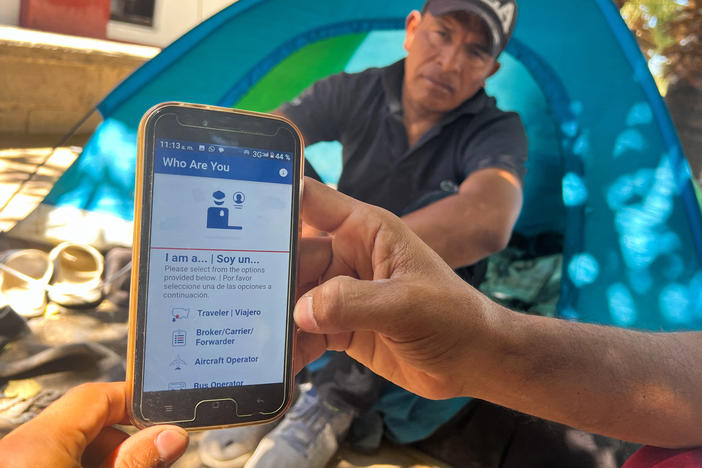 A migrant in Ciudad Juárez, Mexico, displays the CBP One app used to apply for an appointment to claim asylum in the U.S.