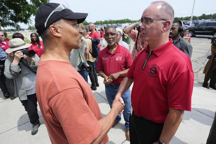 Autoworker Kevin Winston, left, talks with United Auto Workers president Shawn Fain outside the General Motors Factory Zero plant in Hamtramck, Mich., on July 12.