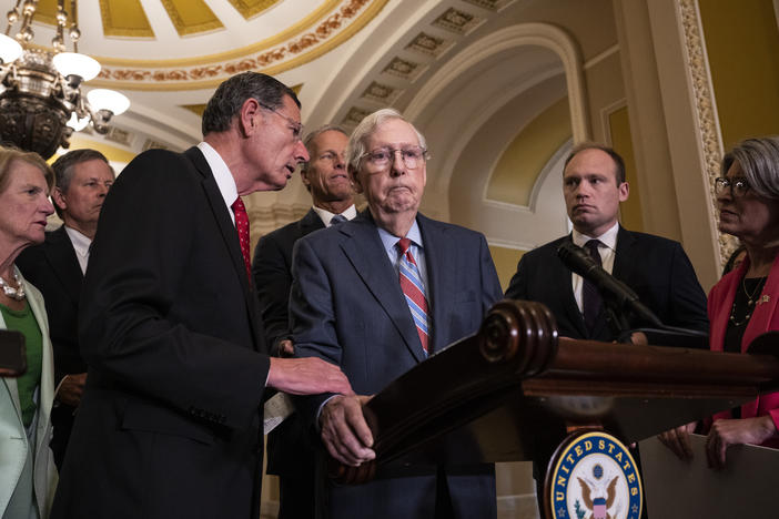 Sen. John Barrasso, R-Wyo., reaches out to help Senate Minority Leader Mitch McConnell, R-Ky., after McConnell froze and stopped talking at the microphone during a news conference after a lunch meeting with Senate Republicans on Wednesday. McConnell was escorted back to his office and later returned to the news conference and answered questions.
