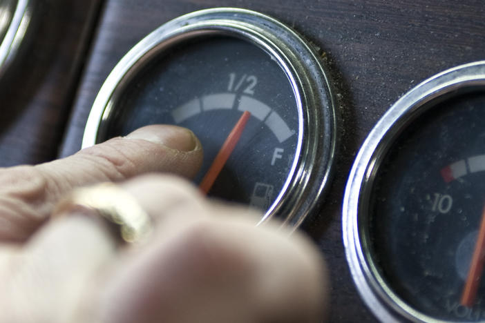 A truck driver points to his fuel gauge in 2008. The Biden administration is now proposing to increase the fuel efficiency of cars and trucks.