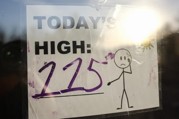 A sign reading "Today's High: 115" is posted in Phoenix, Arizona on July 25.