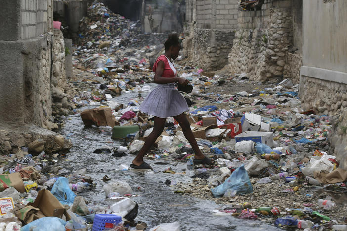 A girl walks through a ravine filled with garbage in Port-au-Prince, Haiti, on July 13.