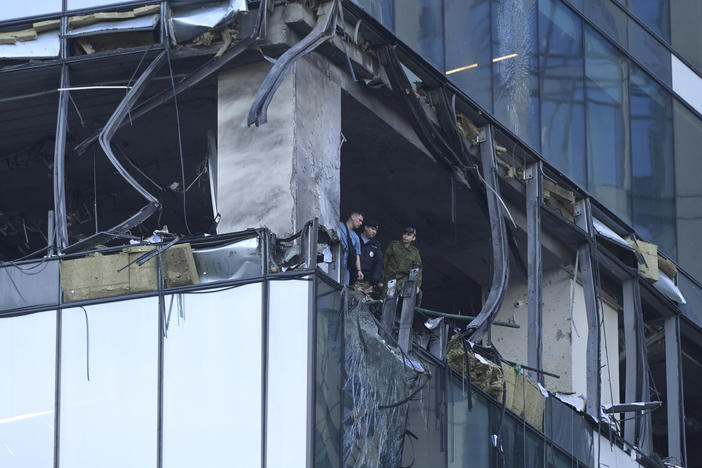 Investigators examine a damaged skyscraper in the "Moscow City" business district after a reported drone attack in Moscow, Russia, early Sunday, July 30, 2023.