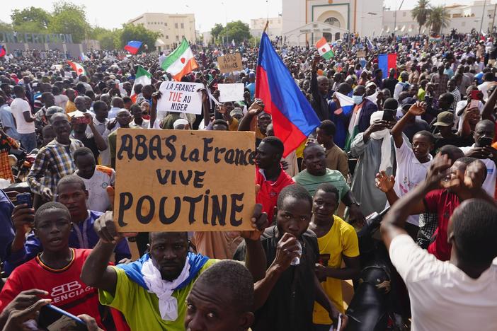 Nigeriens participate in a march called by supporters of coup leader Gen. Abdourahmane Tchiani in Niamey, Niger, Sunday, July 30, 2023. Days after mutinous soldiers ousted Niger's democratically elected president, uncertainty is mounting about the country's future and some are calling out the junta's reasons for seizing control. The sign reads: "Down with France, long live Putin."