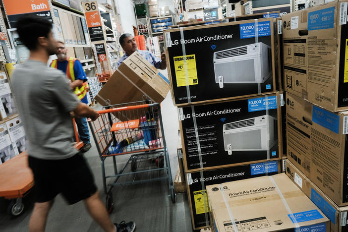People shop for air conditioners during a heat wave last week in New York City. Many people who live in public housing can't afford such units or the utility bills that come with them — and there's no federal requirement for air conditioning.