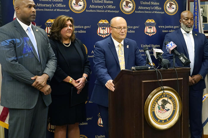 U.S. Attorney Darren J. LaMarca, center, speaks to reporters after six white former law enforcement officers in Mississippi pleaded guilty to federal civil rights offenses in federal court in Jackson, Miss., Thursday, Aug. 3, 2023.