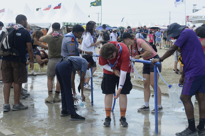 Attendees of the World Scout Jamboree cool off with water at a scout camping site in Buan, South Korea, on Friday.