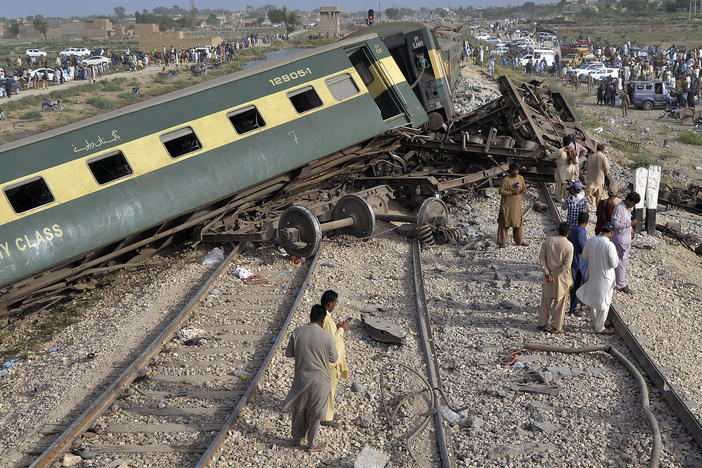 Local residents examine damaged cars of a passenger train which was derailed near Nawabshah, Pakistan. Railway officials say some passengers were killed and dozens more injured when a train derailed near the town of Nawabshah.