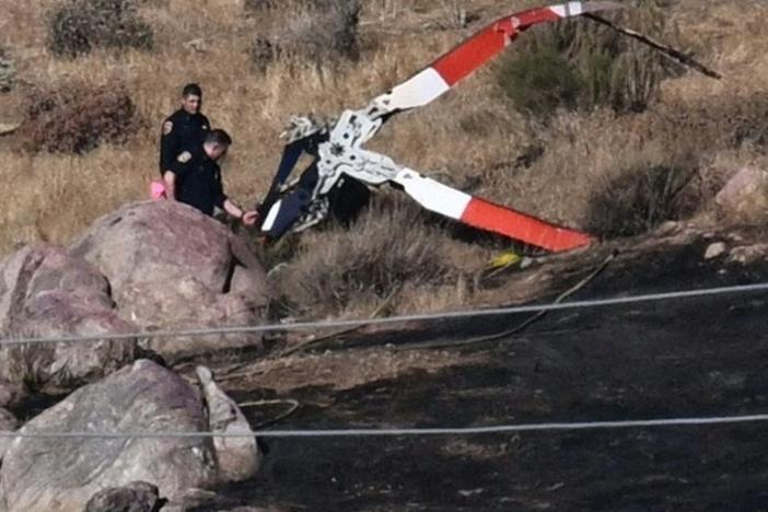 Investigators walk around rotor blades from a crashed helicopter on a burned hillside in Cabazon, Calif., on Monday, Aug. 7, 2023. Three people were killed when their helicopter crashed into a hillside after colliding with another chopper as the team battled a wildfire, emergency officials said. (Photo by Patrick T. Fallon / AFP via Getty Images)