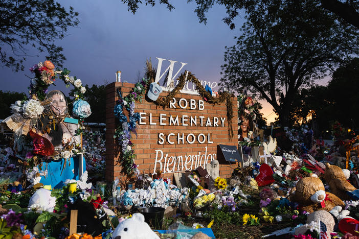 The sun sets behind the memorial for the victims of the massacre at Robb Elementary School in August 2022 in Uvalde, Texas.