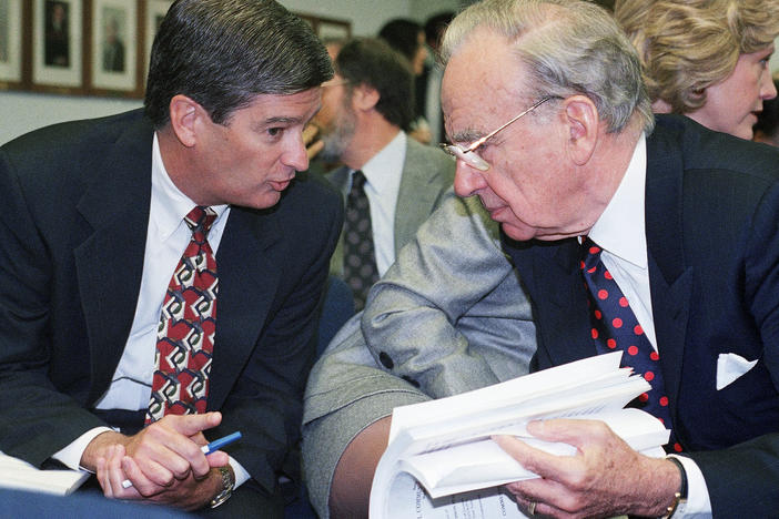 Media magnate Rupert Murdoch, right, huddles with Preston Padden, president of network distribution for Fox, during a hearing of the Federal Communications Commission in May 1995. A generation later, Padden says Murdoch is unfit to hold the licenses for local television stations due to Fox News.