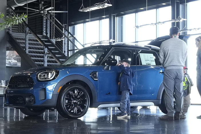 Potential buyers look at a 2023 Cooper Countryman S sports-utility vehicle on the floor of a Mini dealership on Friday, Feb. 17, 2023, in Highlands Ranch, Colo.