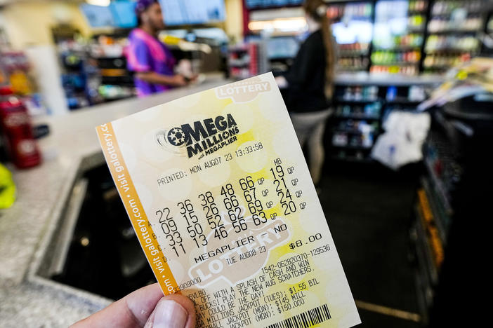 A Mega Millions ticket is seen as a person makes a purchase inside a convenience store, ahead of Tuesday's Mega Millions drawing of $1.55 billion, Monday, Aug. 7, 2023, in Kennesaw, Georgia.