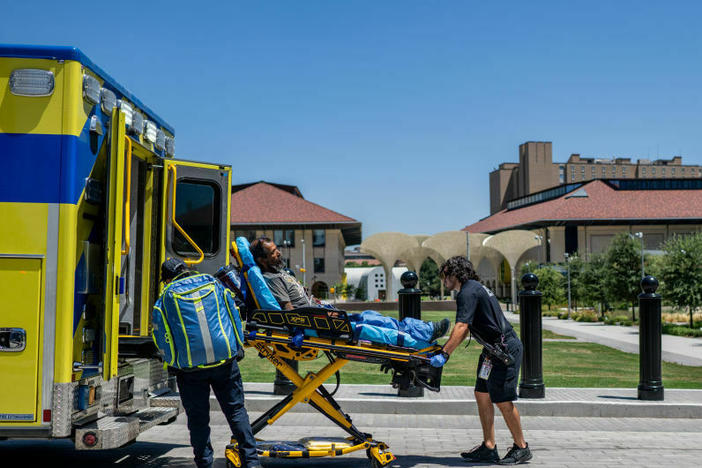 EMTs help a patient in Austin, Texas, this week. The man had passed out near the state capitol and was dehydrated. Cities with few trees and areas of shade are hotter during heat waves.
