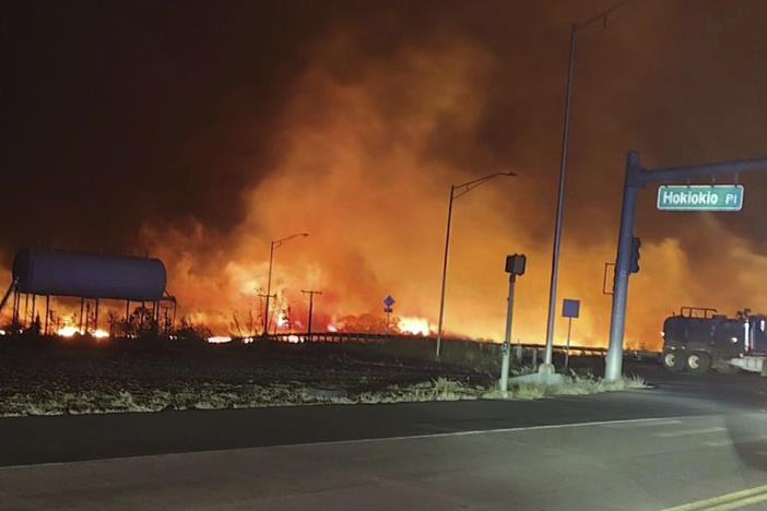 This photo provided by County of Maui shows fire and smoke filling the sky from wildfires on the intersection at Hokiokio Place and Lahaina Bypass in Maui, Hawaii on Tuesday.