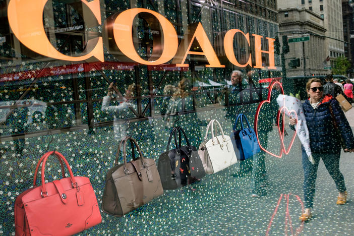 A woman walks past Coach bags in a store window in New York City in 2017.