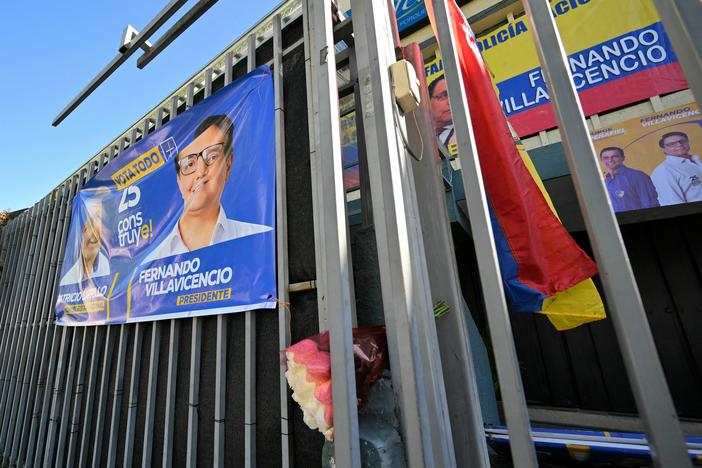 An Ecuadorean flag and a bouquet of flowers are seen on the railings of the sports complex where Ecuadorean presidential candidate Fernando Villavicencio was assassinated on the eve, in Quito on August 10, 2023.