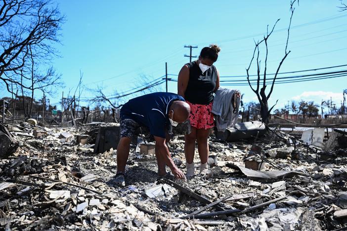 Davilynn Severson and Hano Ganer look for belongings through the ashes of their family's home on Friday in the aftermath of a wildfire in Lahaina, in western Maui, Hawaii.