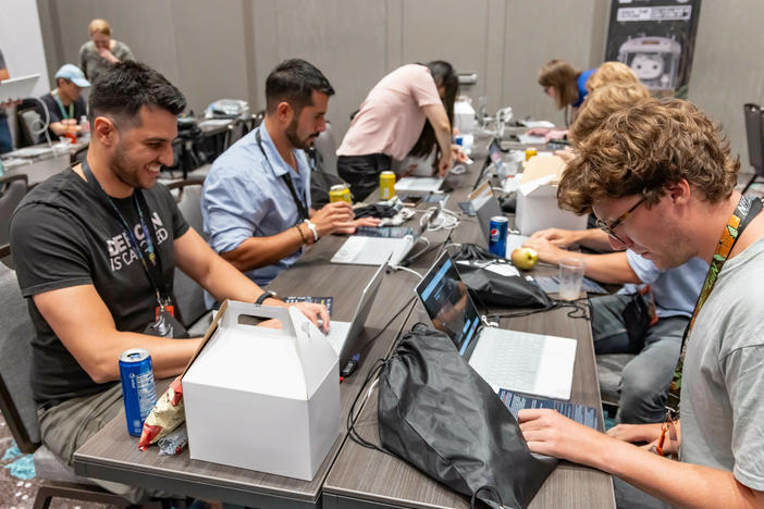 Participants at the 2023 Def Con hacker convention, trying to subvert AI chatbots as part of a contest to test the systems' vulnerabilities.