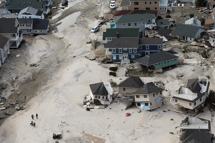 Rescue workers in Seaside Heights, New Jersey, walk past homes wrecked by Superstorm Sandy in 2012. Early reports suggested dozens of people died in the storm, but later assessments found the death toll to be at least 20 times higher.