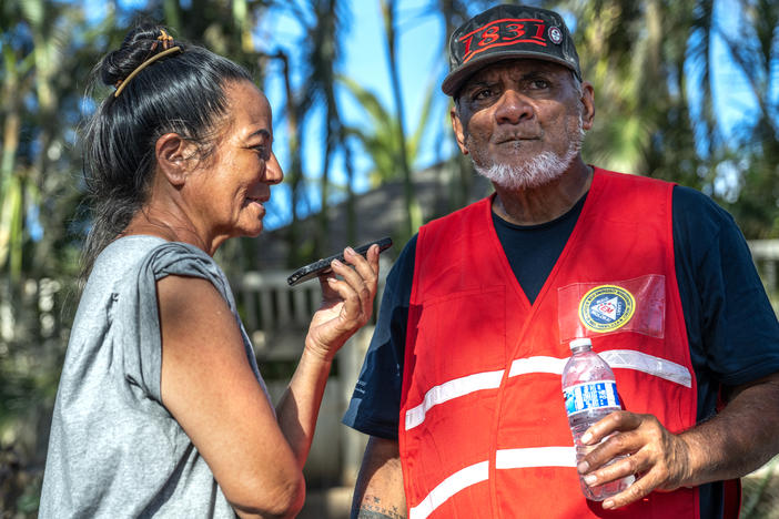 Uilani (left) and Keeamoku Kapu run the Na 'Aikane o Maui Cultural and Research Center which was burned to the ground in the wildfires so they set up this grassroots community distribution center in Lahaina. They are on the phone here taking a call from Oprah about supplies she will be delivering.