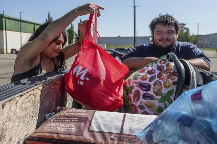 Hay River, N.W.T. fire evacuees Tanisha Edison and her boyfriend Mason Bruneau go through their belongings at the evacuee center in St. Albert, Alberta, on Wednesday, Aug. 16, 2023.