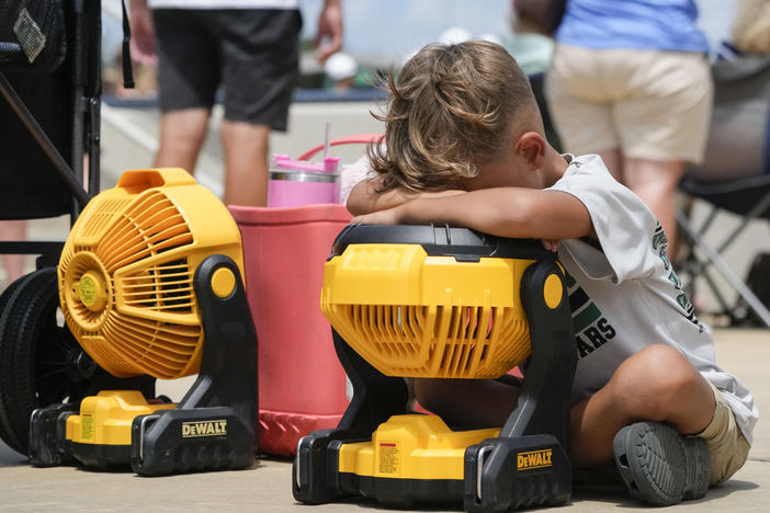 Braxton Hicks, 7, of Livingston, Texas, holds his face to a portable fan to cool off during a Little League tournament in Ruston, La., last week. More very hot weather is expected this weekend in much of the central U.S.