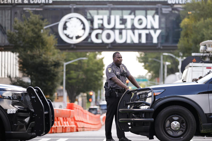 A sheriff's deputy stands guard near the Fulton County Courthouse in Atlanta on Monday. Authorities in Georgia said Thursday they're investigating threats targeting members of the grand jury that indicted former President Donald Trump and 18 of his allies.