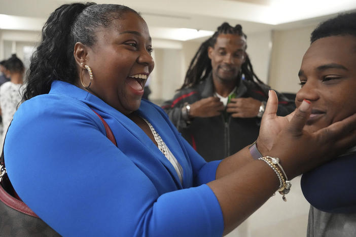 Valerie Laveus greets her nephew Tristan-Ryan Malherbe Daniel, as he and his dad, Reginald Malherbe Daniel, rear, arrive in the U.S. for the first time at Fort Lauderdale-Hollywood International Airport, in Fort Lauderdale, Fla.