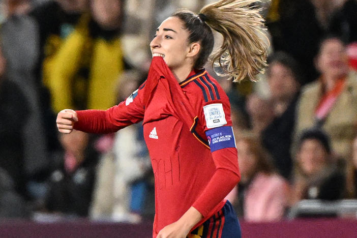 Spain's Olga Carmona points to the message she had written on her undershirt to honor the death of one of her best friend's mother after scoring what would be the only goal in the match against England on Sunday. Carmona later learned that her father had died before the final match.