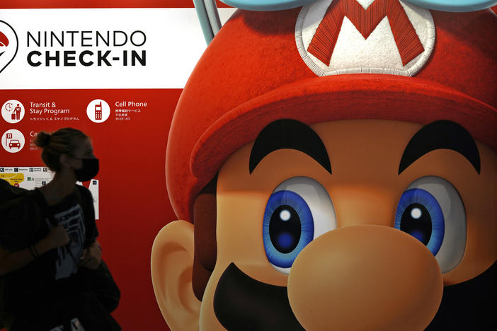 A person passes an ad featuring the Nintendo character Mario at Narita airport in Narita near Tokyo on June 10, 2022.