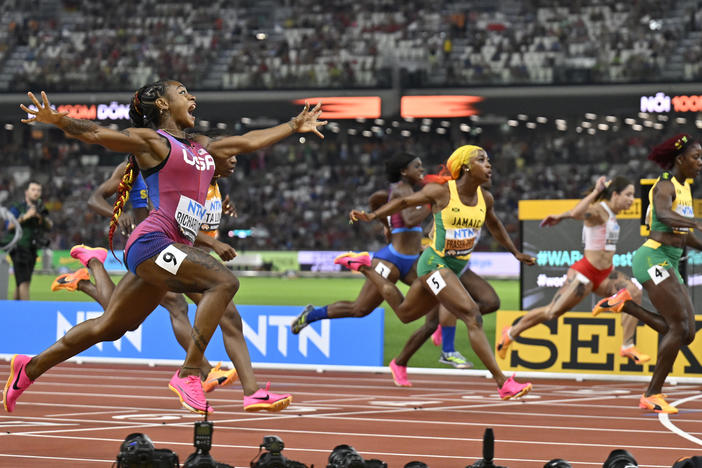 Sha'Carri Richardson, of the United States, spreads her arms as she crosses the line to win the women's 100-meter final during the World Athletics Championships in Budapest, Hungary.