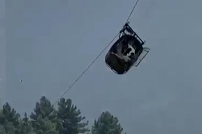In this image taken from video, a cable car carrying six children and two adults dangles hundreds of feet above the ground in the remote Battagram district, Khyber Pakhtunkhwa, Pakistan, on Tuesday. A rescue mission is underway.