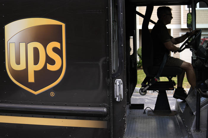 United Parcel Service driver Hudson de Almeida steers through a neighborhood while delivering packages, June 30, 2023, in Haverhill, Mass.