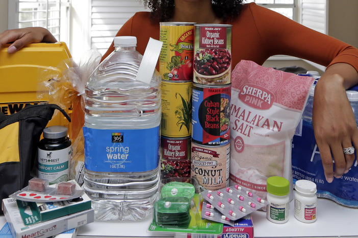 In this Friday, Sept. 29, 2017, photo, Lexi Montgomery poses with supplies she has purchased in the event of another storm, in Miami Beach, Fla. Hurricane Irma was the first hurricane that Montgomery ever experienced. (AP Photo/Alan Diaz)