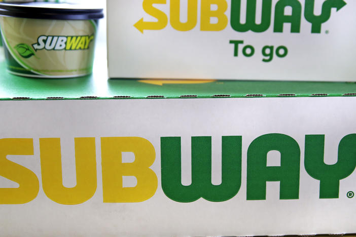 The Subway logo is seen on takeout boxes at a restaurant in Londonderry, N.H. The sandwich chain says it will be sold to the private equity firm Roark Capital. Terms of the deal weren't disclosed.