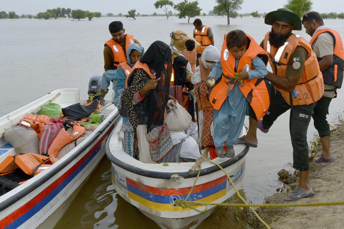 Rescue workers evacuate villagers through a boat from a flooded area of Pakpattan district of Pakistan's Punjab province, Wednesday, Aug. 23, 2023.