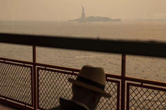 The Statue of Liberty is seen June 7 through a haze-filled sky from the Staten Island Ferry in New York. The smoke from Canadian wildfires that drifted into the U.S. led to a spike in people with asthma visiting emergency rooms — particularly in the New York area.