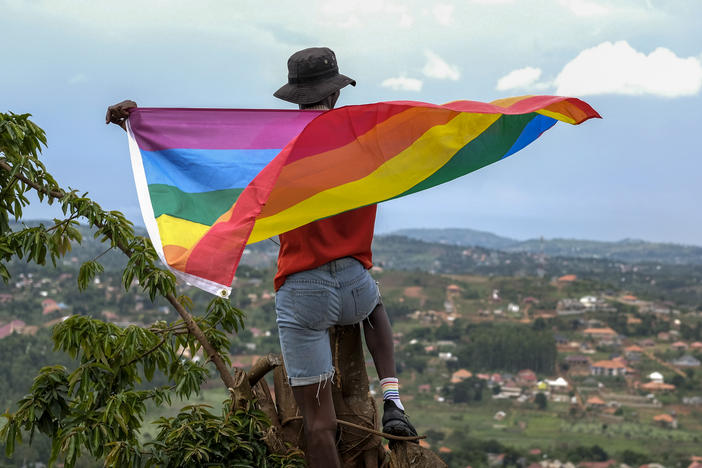 A gay Ugandan man holds a pride flag as he poses for a photograph in Uganda in March.