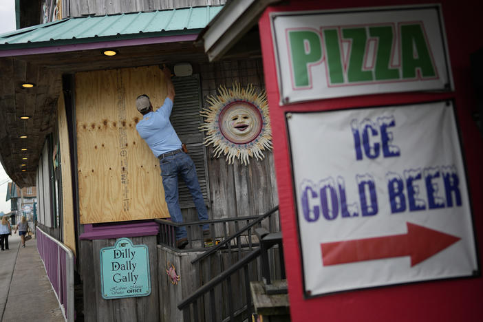 Adam Henderson, owner of Harbour Master Suites, prepares his business Tuesday in Cedar Key, Fla., ahead of the expected arrival of Hurricane Idalia.