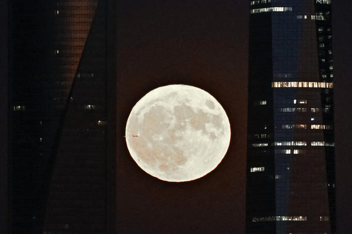 This picture taken on Aug. 1, 2023, shows the second supermoon of 2023, also known as the sturgeon moon, rising behind the Cuatro Torres business area in Madrid.