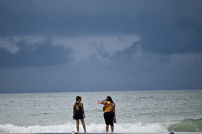 People are shown at the beach in Tampa, Fla., on Tuesday as the city prepares for Hurricane Idalia.