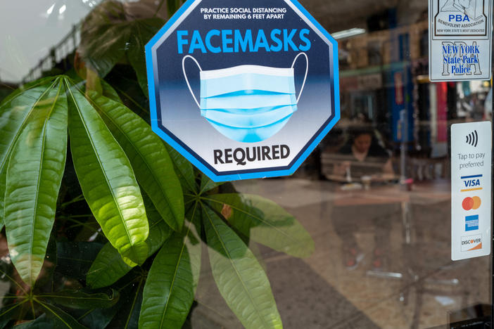 A face mask sign is displayed in a window in Queens, New York City on May 11, the day the federal public health emergency for COVID ended.